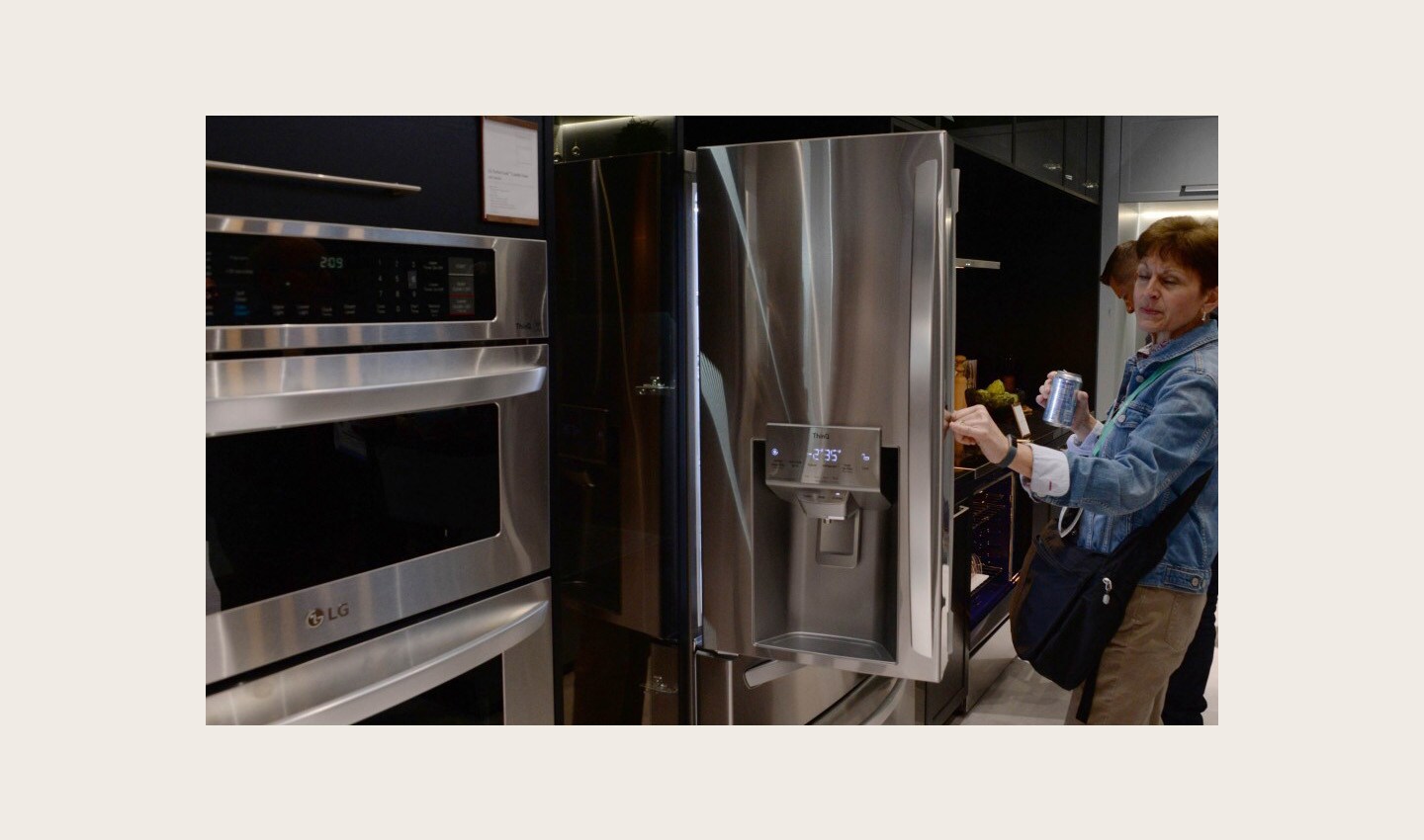 A visitor to the LG booth opens one of the company’s advanced refrigerators while looking toward the innovative oven range which is on display to its side