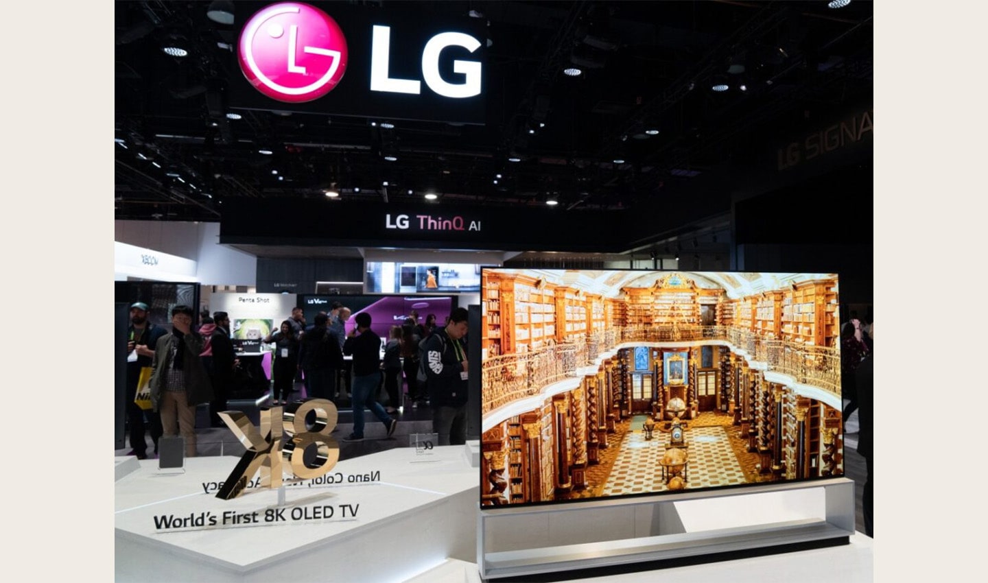 Front view of an LG 8K OLED TV set positioned on the right side of a promotional sign saying 
