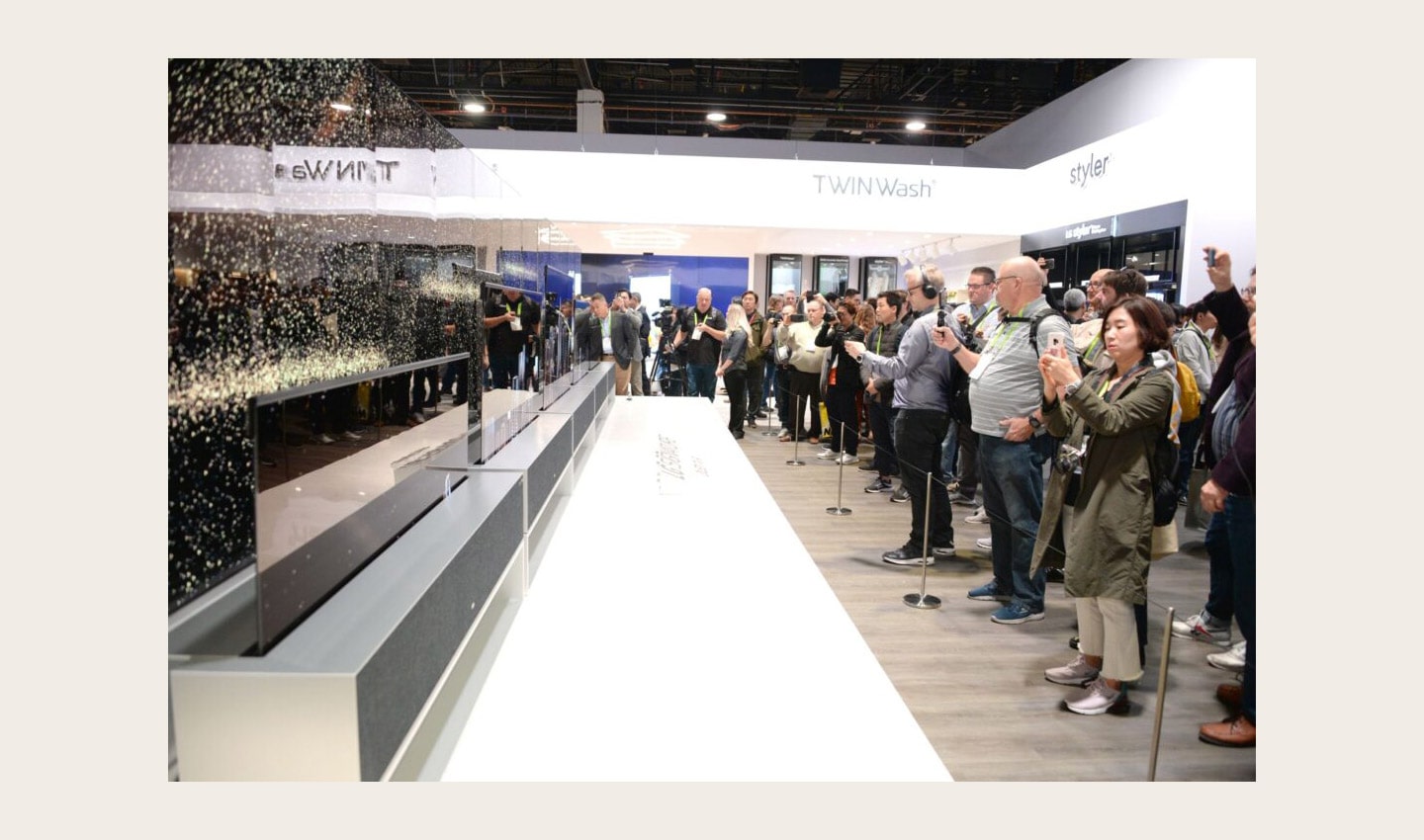 Side view of LG SIGNATURE OLED TVR display zone with CES visitors viewing the display and taking pictures