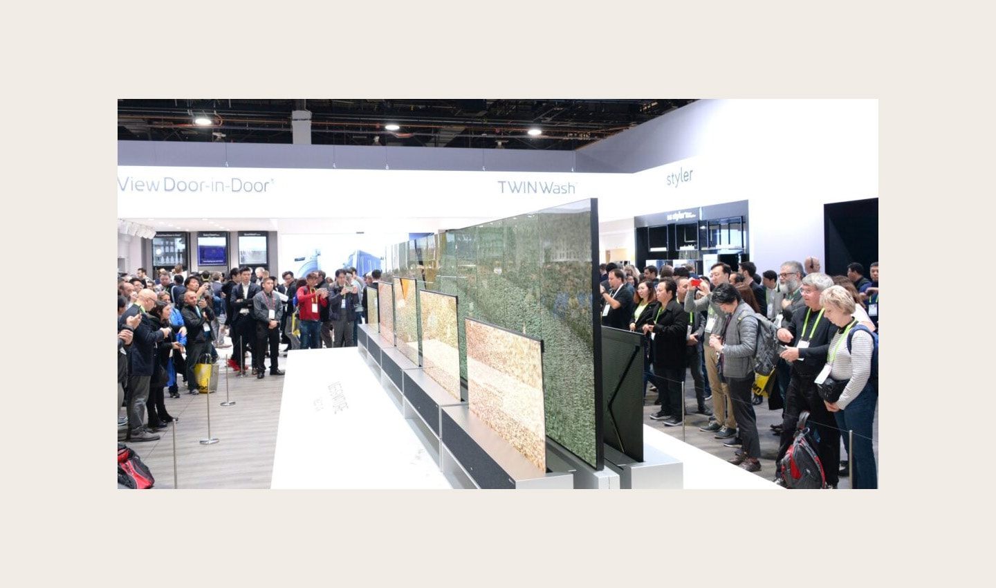Another view of LG SIGNATURE OLED TVR display zone with CES visitors viewing the display and taking pictures