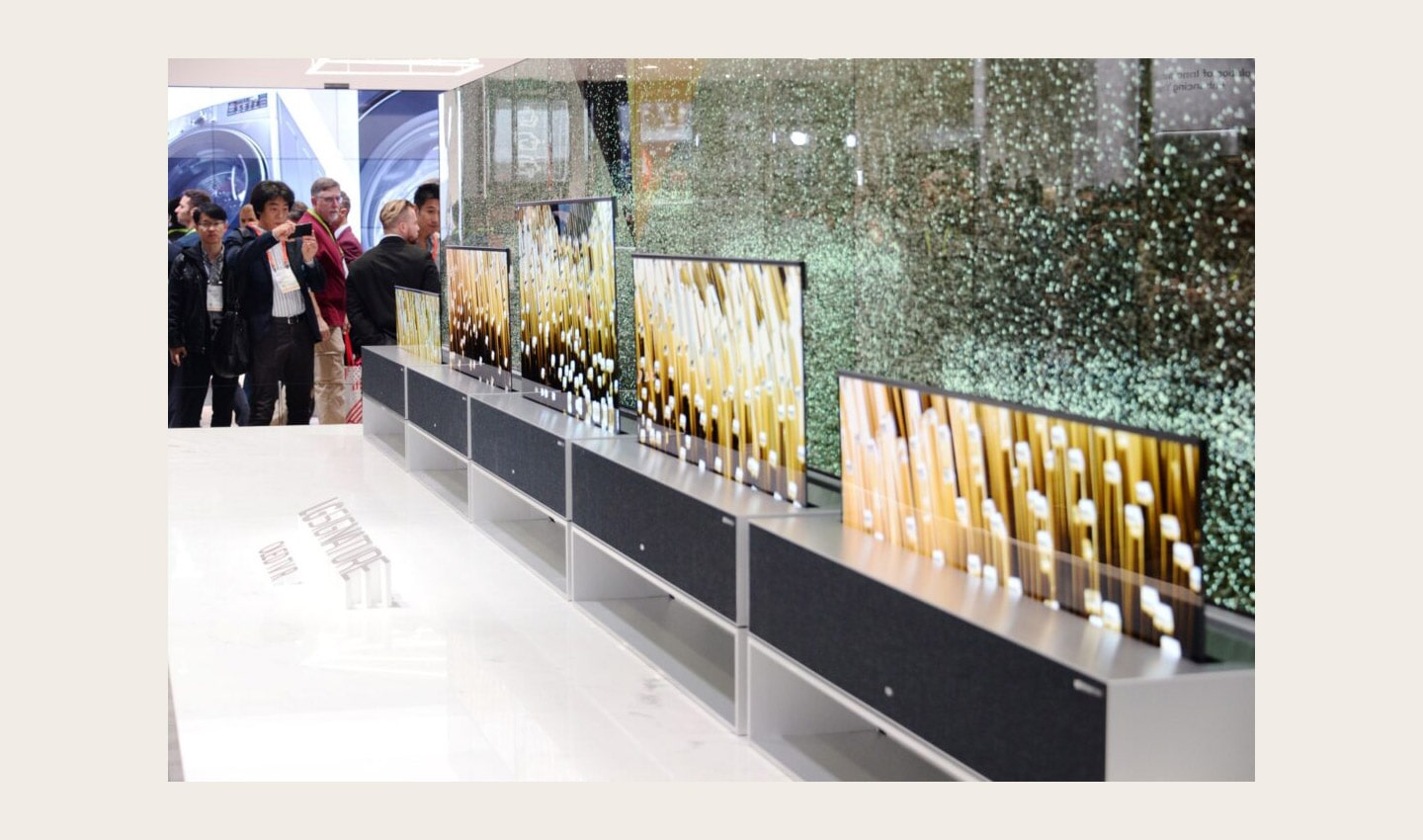 Closer view of LG SIGNATURE OLED TV R display zone with CES visitors viewing the display and taking pictures