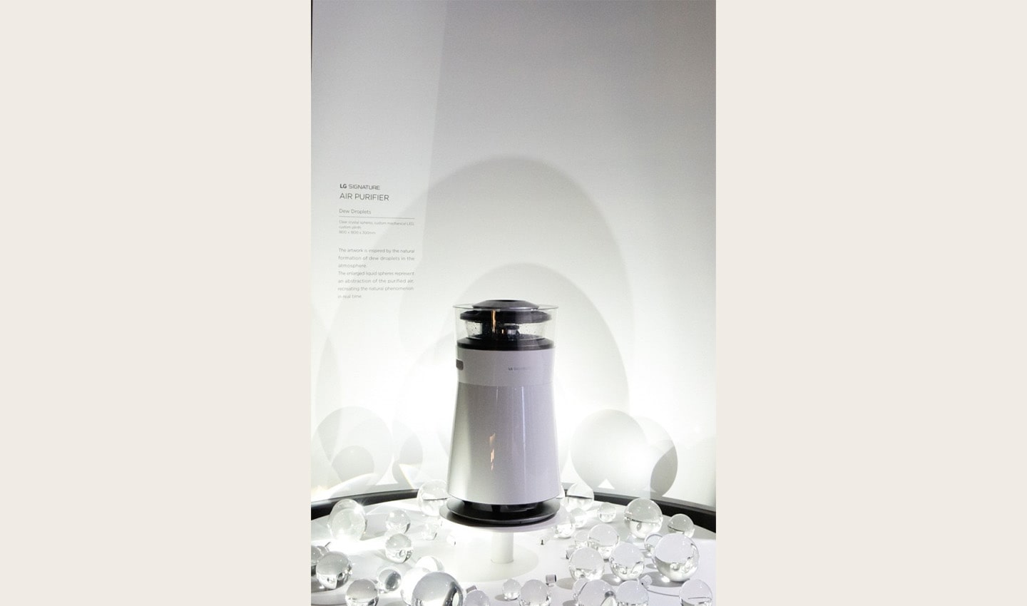 Front view of the LG SIGNATURE Air Purifier in front of the information display about the product