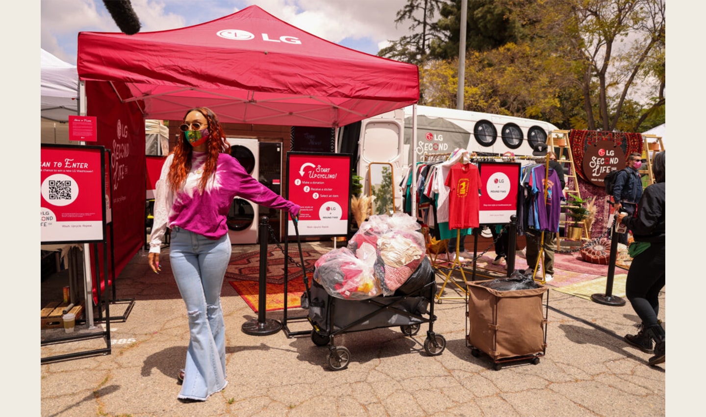 A woman pulling along several full bags of clothing ready to be donated to families in need.