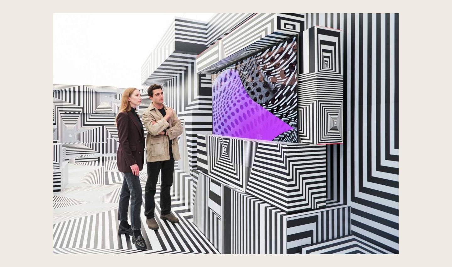 Two visitors taking a closer look at LG OLED-powered “Into the Maze” installation by the German artist, Tobias Rehberger