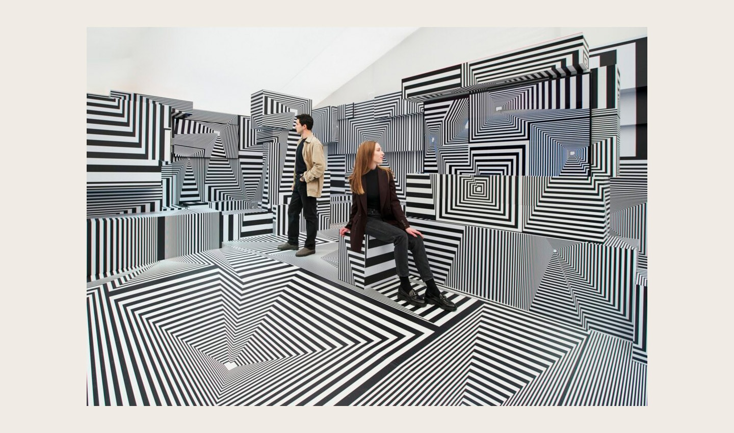 Two visitors posing at LG OLED-powered “Into the Maze” installation by the German artist, Tobias Rehberger