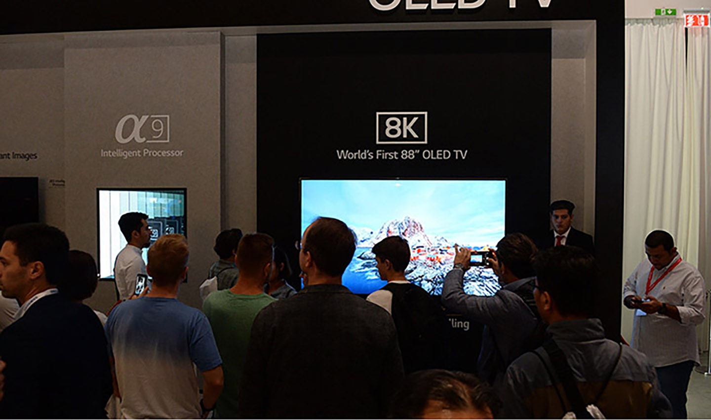 World’s First 8K OLED TV with A9 Intelligent Processor display zone at IFA 2018 with conference attendees walking around and looking at the display