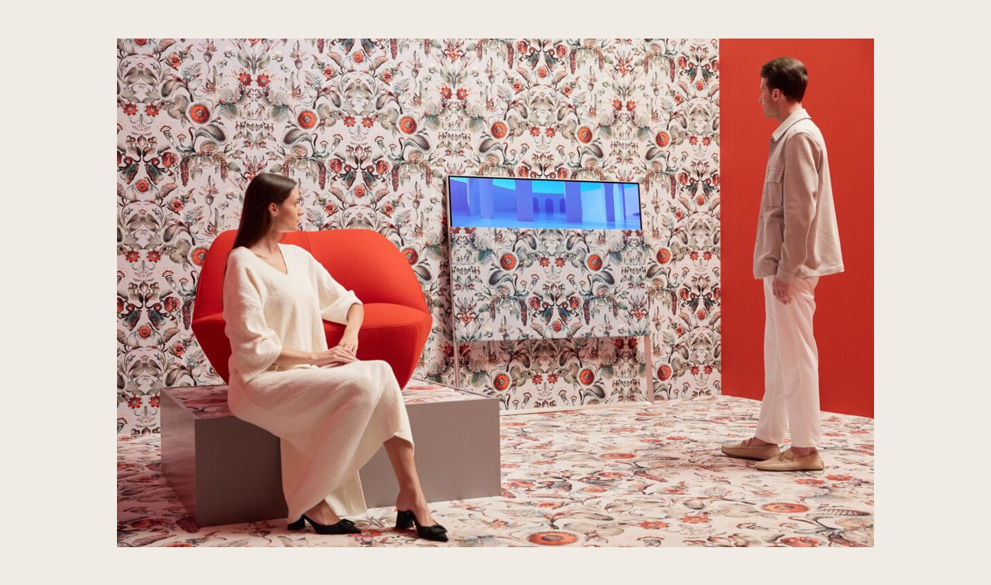 A man and women enjoying the artistic white and red Moooi space designed to display LG OLED Objet Collection Posé and LG PuriCare AeroFurniture in unique patterns and colors