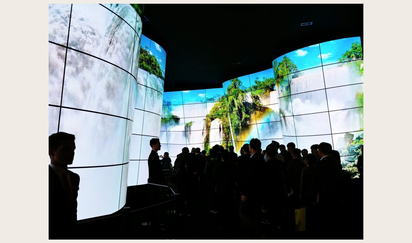People standing before the entrance of the LG OLED Canyon, which displays a huge waterfall