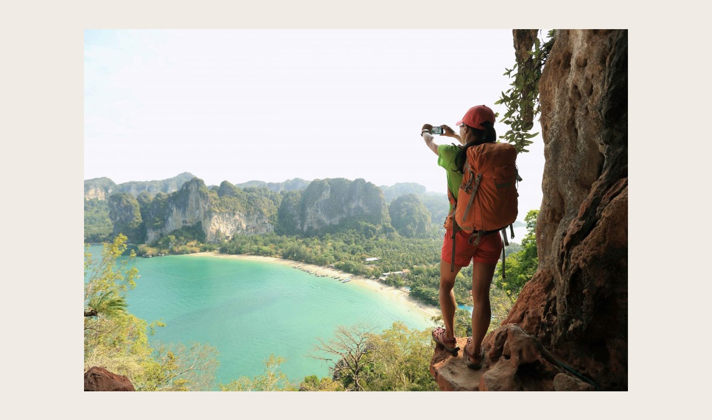 A woman stands in a nature scene taking a photo of the view with the LG X Venture.