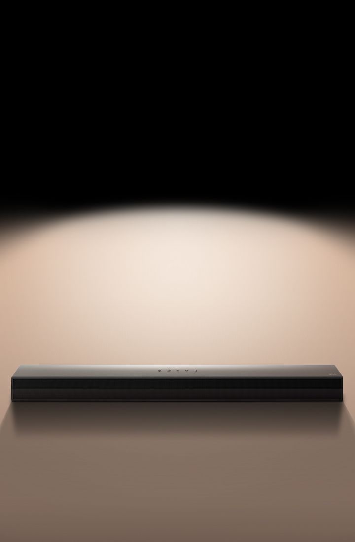 聚光燈突顯在黑色背景下的 LG Soundbar。