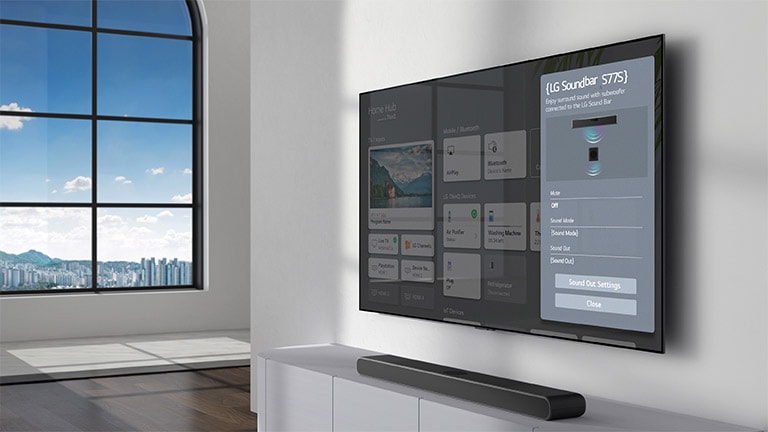 LG Sound Bar 設定螢幕顯示在壁掛式安裝電視上。Sound Bar 同樣掛在電視下方。