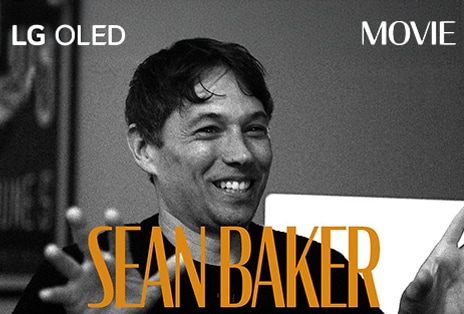 一張黑白靜止圖像，來自與 Sean Baker 的訪談。其名字以橙色粗體字出現在畫框底部。短語 LG OLED 位於左上角，單詞「電影」位於右上角。