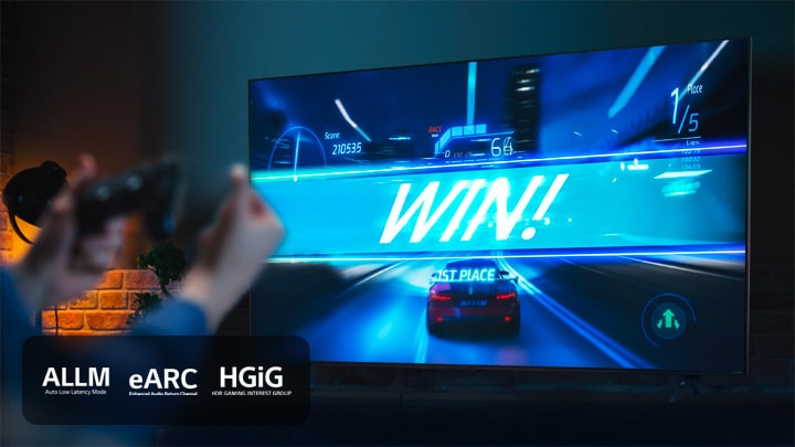 A car racing game on the finish line, with the sign saying 'WIN!', as the player clenches on to the game joystick. ALLM, eARC, HGiG logo are placed on the bottom left corner.	