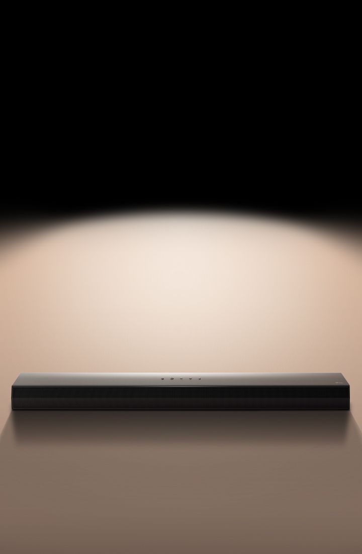 An image of the LG Soundbar against a black backdrop highlighted by a spotlight. 