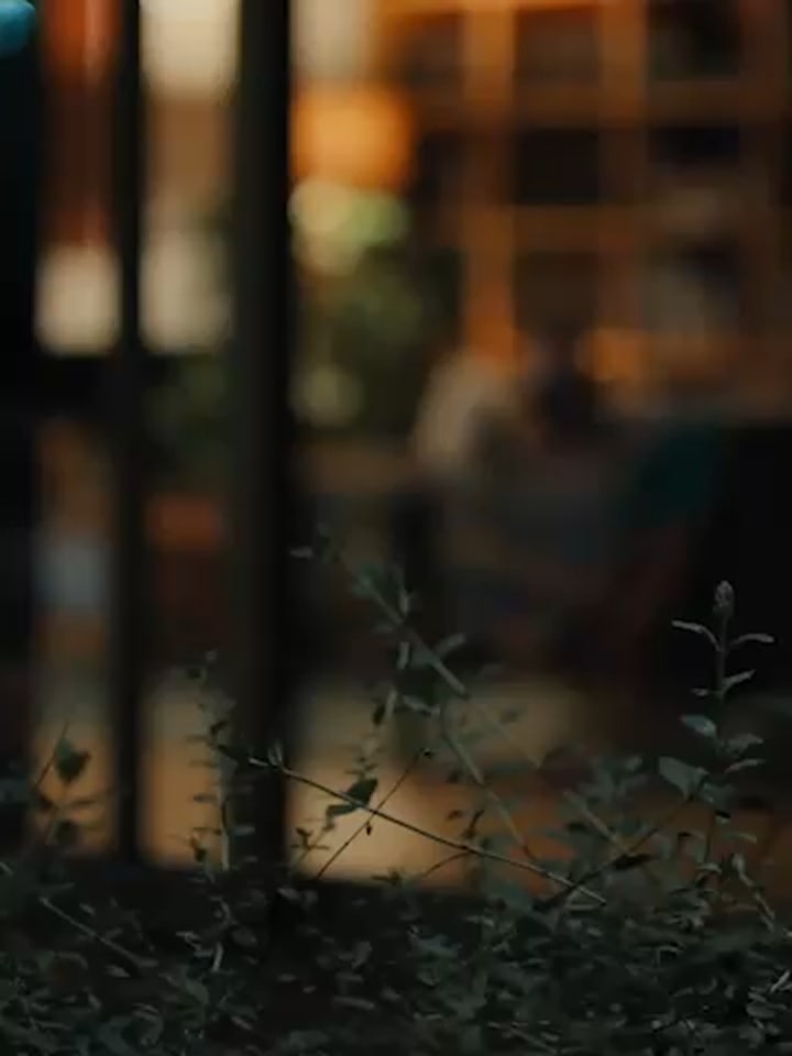 A man and a woman lie intertwined on the living room sofa while the LG TV plays a cooking channel. After the woman falls asleep, the man calls out, "Hi LG," asking to play the soccer match, and the channel switches to the game.