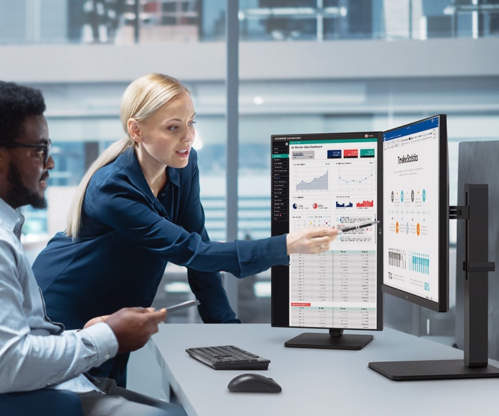 Two male and female employees discuss while looking at the monitor in the office.