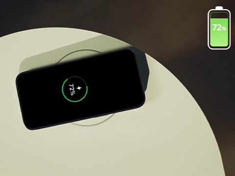 A smartphone is being charged on top of a wireless charger on an Aero Furniture.