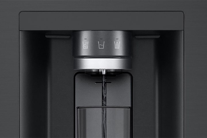 A video starts zoomed in on the water dispenser. The exterior of the refrigerator goes clear and now the interior of the door and mechanical parts of the dispenser nozzle can be seen. The video zooms in further to show the water droplets as they fall through the UVnano part of the nozzle which reduces the bacteria. The view zooms back out to see the exterior of the refrigerator again as water is being dispensed into a glass.