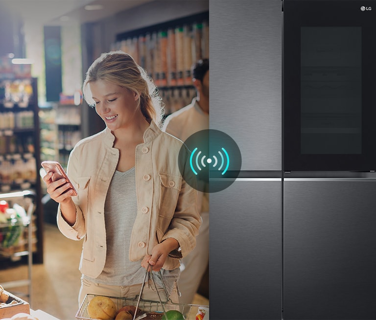 Image on the left shows a woman standing in a grocery store looking at her phone. Image on the right shows the refrigerator front view. In the center of the images is an icon to show connectivity between the phone and refrigerator.