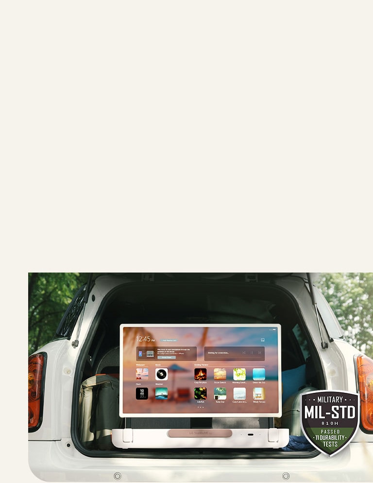 Front view of LG StanbyME Go. The product is placed in the car, the screen rorated horizontally, showing home screen. On the bottom-left side of the image, military spec icon is shown.