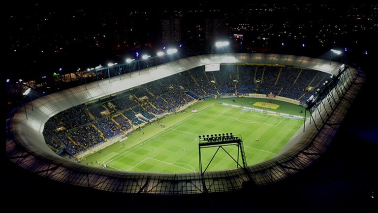 An aerial view of a stadium with a video play button