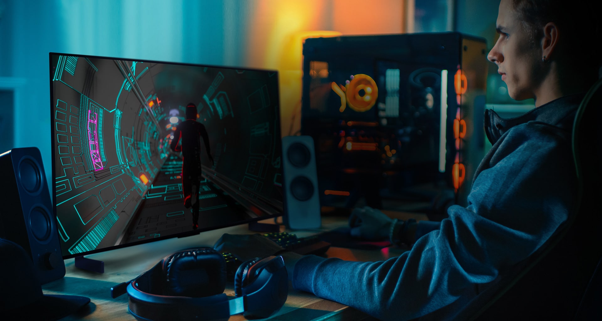 A person plays a sci-fi game at his personal desk on a small LG OLED television