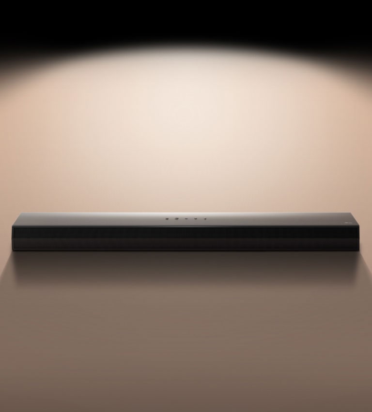 LG Soundbar képe fekete háttér előtt, reflektorral kiemelve.