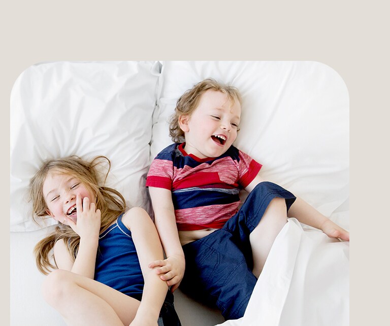 Két gyermek játszik az ágy körül