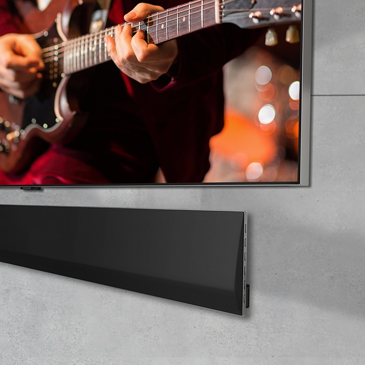 Közeli, térbeli perspektíva egy falra szerelt LG OLED TV és LG Soundbar aljáról.