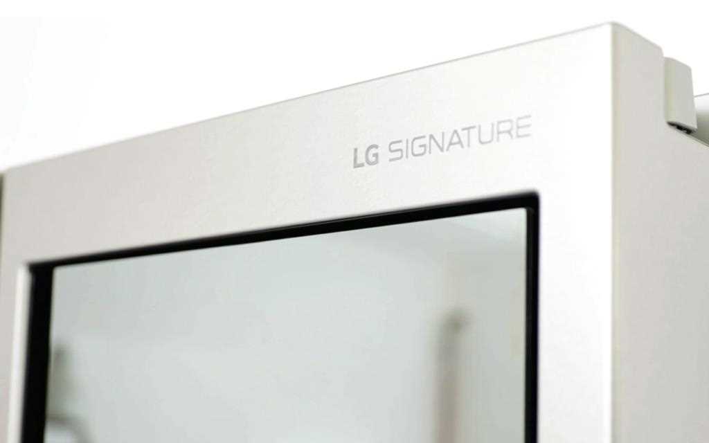 LG SIGNATURE symbol on LG InstaView refrigerator with glimpse of the see-through door