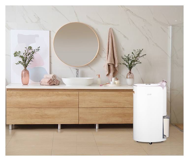 Menampilkan warna white rose gold yang elegan dari Dehumidifier LG Puricare™ yang ditempatkan di kamar mandi.