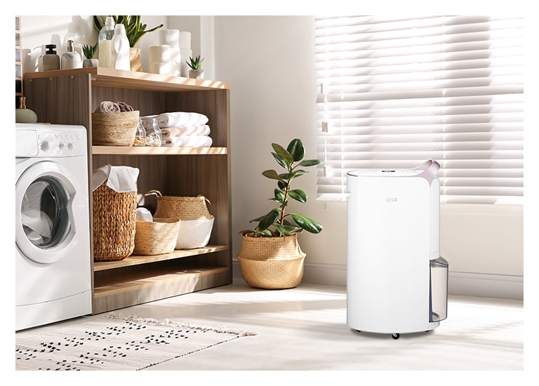 Menampilkan warna white rose gold yang elegan dari  Dehumidifier LG Puricare™ yang ditempatkan di ruang cuci.