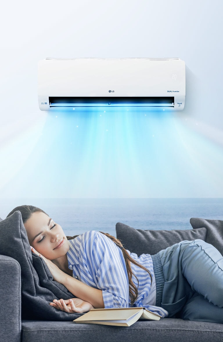 Seorang wanita beristirahat dengan nyaman di atas sofa dengan penyejuk ruangan yang mengembuskan udara di atasnya.