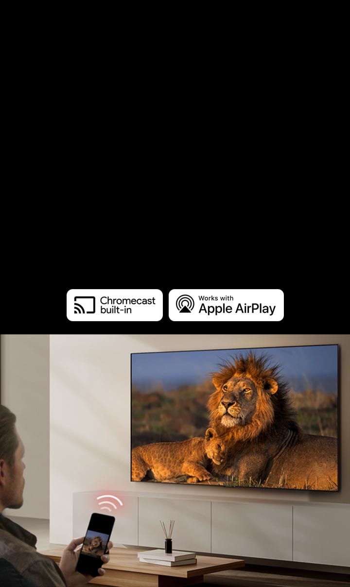 LG TV yang dipasang di dinding ruang tamu, menampilkan gambar singa dan anaknya. Seorang pria duduk di latar depan dengan smartphone di tangannya menampilkan gambar singa yang sama. Grafik tiga batang melengkung berwarna merah neon ditampilkan tepat di atas smartphone yang mengarah ke TV.