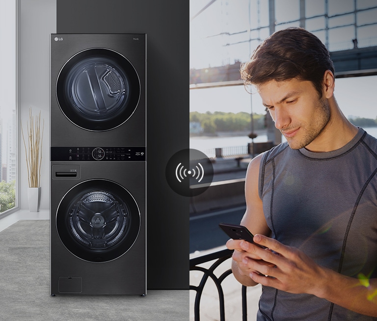 A man outdoors is checking the condition of a washing machine at home through a mobile phone app.