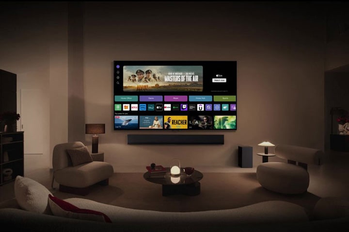 LG TV mounted on the wall shows the screen of WebOS supporting Home Office, LG Channels, Game, and Music.