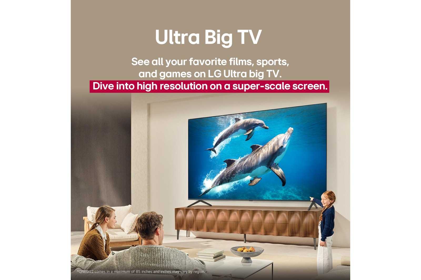 A family sits on a couch facing a LG QNED TV mounted on a wall above a LG Soundbar with a little girl pointing to a screen depicting two dolphins. The title talks about how every action is more thrilling on a massive screen.