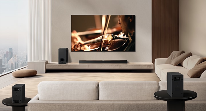 LG Soundbar, LG TV, a subwoofer and rear speakers are in a modern city apartment. The background gets dimmed, and the grid overlay appears over the image from LG TV, like a scan of the space. A dotted line extends from one of the rear speaker, to show the two rear speakers are in a linear fashion. White soundwaves made of droplets are coming out from the frontal perspective of the rear speakers.