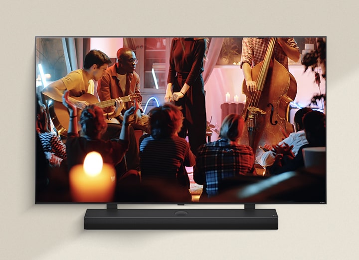 A cozy concert is playing on an LG TV with an LG Soundbar underneath.