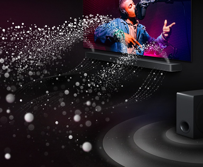 LG Soundbar S90TY and LG TV in a black room playing a musical performance. White droplets representing soundwaves shoot upwards and forward from the soundbar. A subwoofer is creating a sound effect from the bottom.