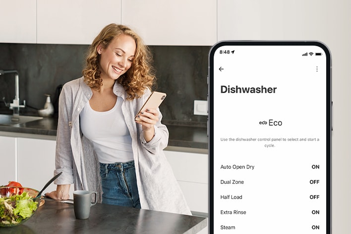 A woman is looking at her cell phone in the kitchen and a smartphone shows personalization settings in the ThinQ™ app.