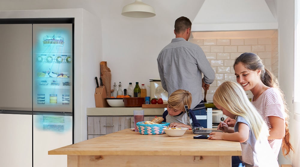 The whole family is sitting at the table preparing a meal. InstaView refrigerator installed on one side of the kitchen is creating cool air quickly.