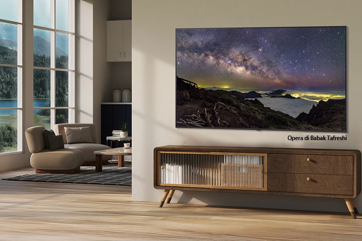 Interno di una casa di campagna in cui è installato un TV LG su cui si vede un'opera d’arte raffigurante un paesaggio naturale. Il televisore sembra una fotografia appesa al muro.