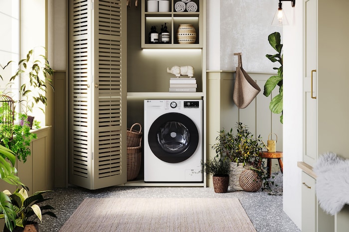 La lavatrice LG F4R7011TSWC da 11kg bianca dal design elegante, installata ordinatamente sotto il bancone di una lavanderia moderna.