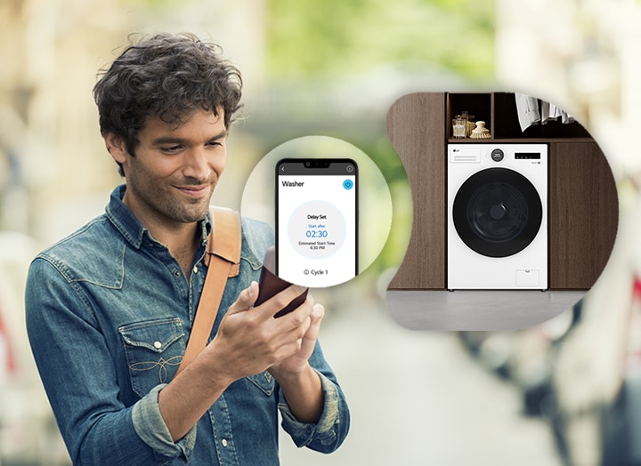 Un uomo usa l'app guardando il cellulare. Sullo sfondo c'è una lavatrice.
