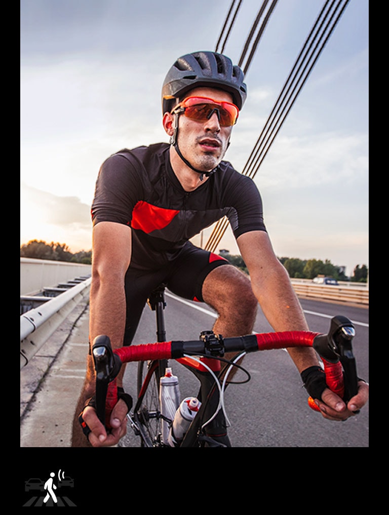 Un uomo con le cuffie TONE Free Fit sta guidando una bicicletta.