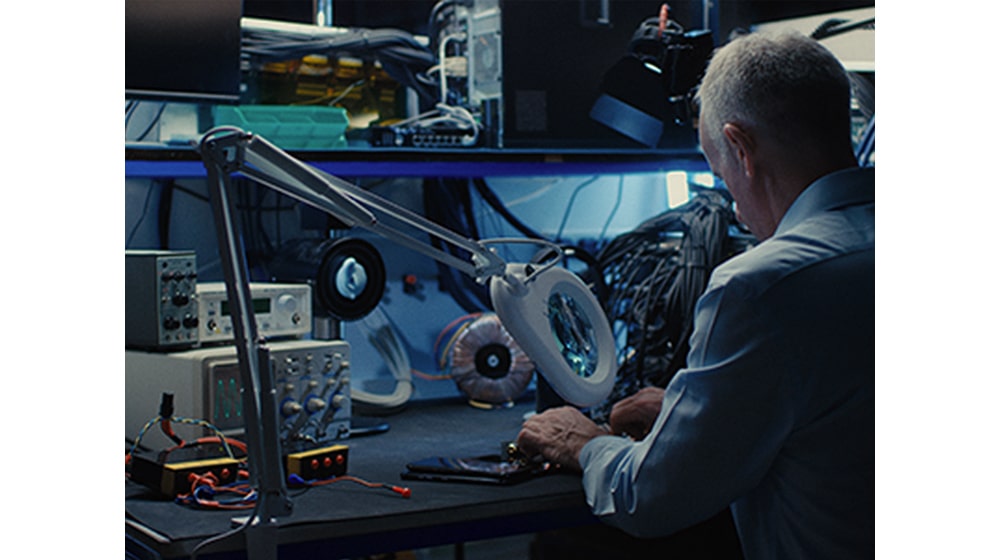 Un uomo sta lavorando su delle macchine professionali alla sua scrivania.