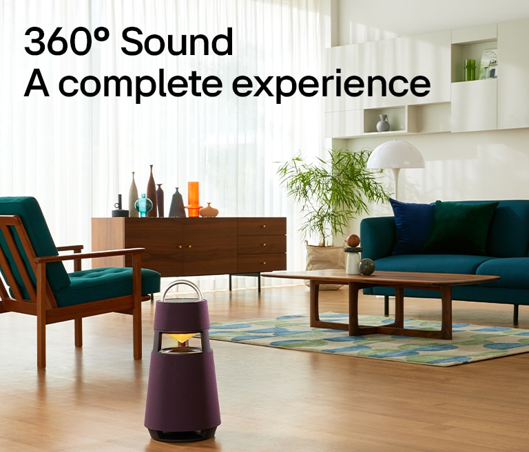 Immagine di una donna seduta sul divano che ascolta la musica, di fronte a lei si vede il prodotto XBOOM 360.