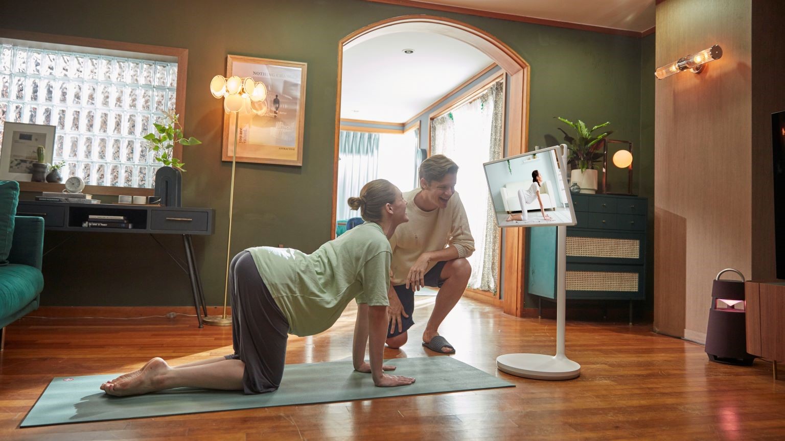 Come allenarsi a casa, gli strumenti indispensabili per la home gym: donna incinta che fa un allenamento a casa lo schermo personale StanbyME LG