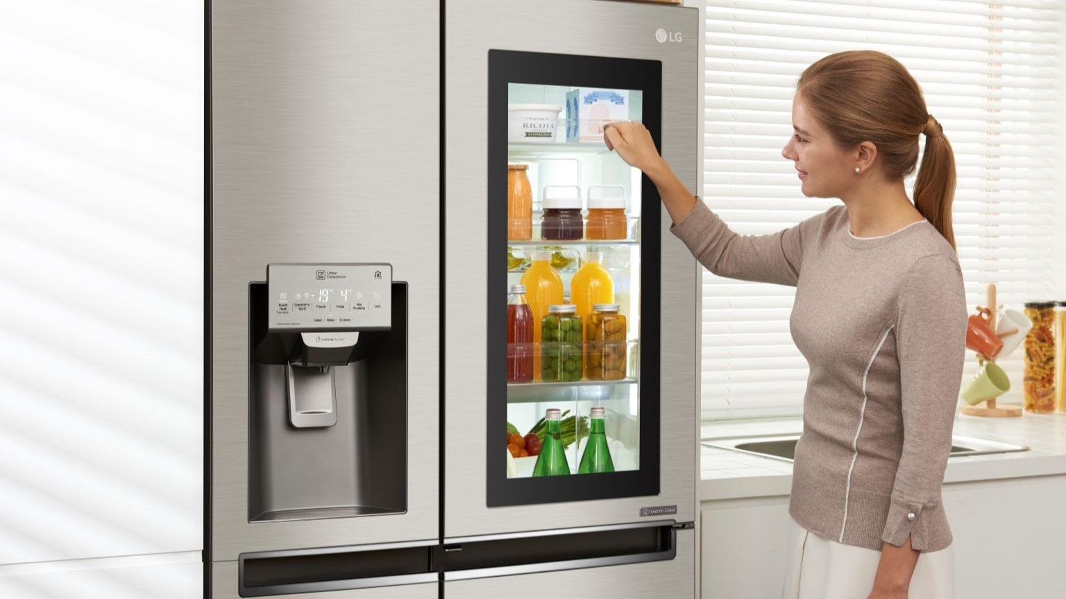 Come conservare frutta e verdura: persona che controlla cosa nel frigorifero LG MoodUP bussando sulla parete esterna.